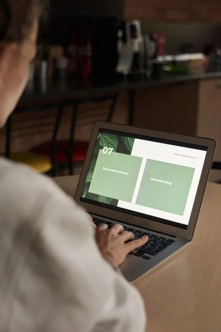 A Lenovo laptop displaying Facebook login beside a lavender plant indoors.